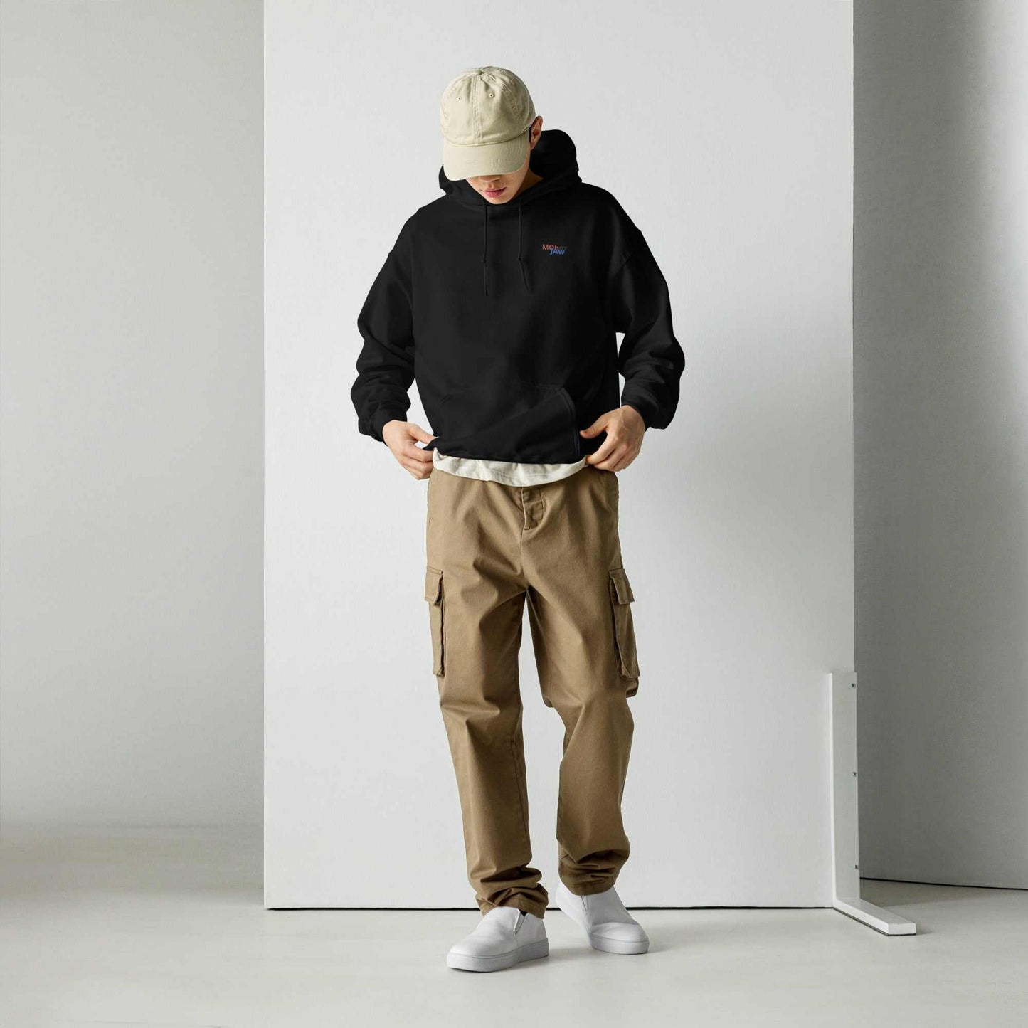 Felpa Moh_Jaw07 indossata da giovane in capo nero con pantaloni beige, in ambiente moderno e casual.